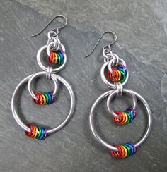 "These rainbow earrings feature lightweight silver aluminum and anodized aluminum rings in all the colors of the rainbow. There are smaller hoops suspended within larger hoops, with three sets of rainbow rings. The earrings have niobium earwires and are quite light due to the materials I use to create them, so they are easy on the ears. Length: 2 3/4\" Width at Widest Point: 1 1/4\" Colors: Rainbow, Silver Materials: Anodized Aluminum Rings, Bright Aluminum Rings Earwires: Niobium French Hooks Y Rainbow Dangle Metal Earrings, Hypoallergenic Rainbow Colored Metal Jewelry, Hypoallergenic Rainbow Metal Jewelry, Rainbow Metal Earrings With Ear Wire, Rainbow Metal Earrings, Multicolor Metal Hoop Earrings, Rainbow Hypoallergenic Hoop Earrings, Hypoallergenic Rainbow Hoop Earrings, Nickel Free Multicolor Metal Hoop Earrings