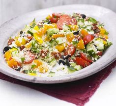 a white plate topped with salad on top of a table