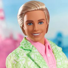 a close up of a barbie doll with blonde hair and blue eyes wearing a green sweater