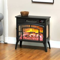 a small stove with a fire burning in it's center and a chair next to it