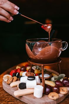 a chocolate fondant being drizzled over marshmallows and fruit