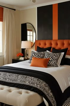 a bedroom with orange and black accents on the walls, white bedding, and an upholstered headboard