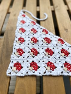 a crocheted triangle sitting on top of a wooden bench