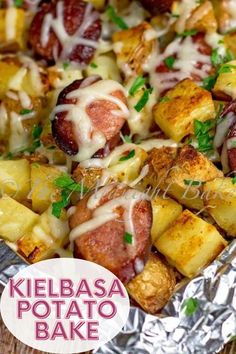 a pan filled with potatoes and ham covered in cheese on top of aluminum foil next to a wooden table