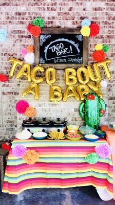 a taco bout birthday party with balloons and decorations on the wall, including a table