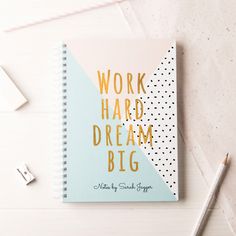 a notebook with the words work hard, dream big on it next to a pencil