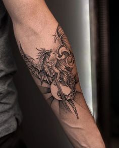 a man's arm with a bird and flower tattoo on the left side of his arm