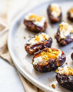 an assortment of stuffed figs on a platter with cheese and herbs sprinkled on top