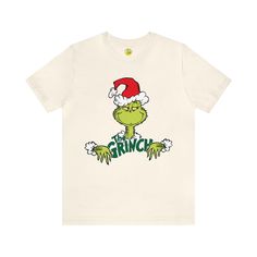 a white t - shirt with the grin on it's chest and santa hat