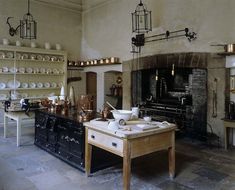 an old fashioned kitchen with lots of pots and pans