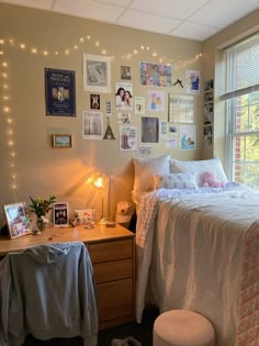 a bed room with a neatly made bed and lots of pictures on the wall