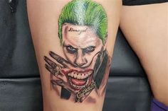 the joker tattoo is on someone's leg and it looks like he has green hair