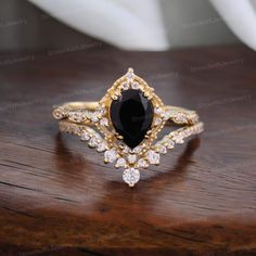 a black and white diamond ring sitting on top of a wooden table