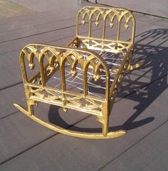 a gold metal bed frame sitting on top of a wooden floor next to a building