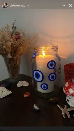 a candle is sitting on a table next to some rocks and other items that are placed around it