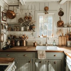 a kitchen with lots of pots and pans hanging on the wall above the sink