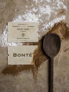 a wooden spoon sitting on top of a table next to a sign that says bonte