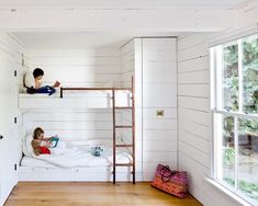 two children are sitting on bunk beds in a room with white walls and wood flooring