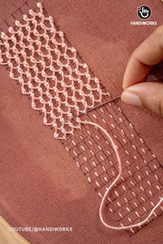 someone is working on a piece of fabric that has been stitched together with scissors