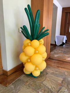 a large balloon pineapple sitting on top of a stone floor next to a doorway