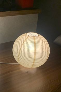 a white lamp sitting on top of a wooden table