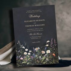 a black wedding card with flowers on it