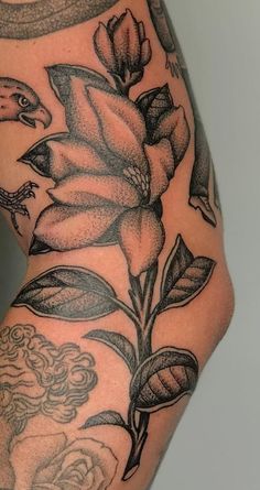 a woman's leg with tattoos and flowers on it