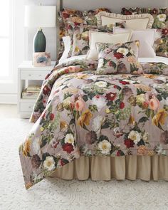 a bed with a floral comforter and pillows