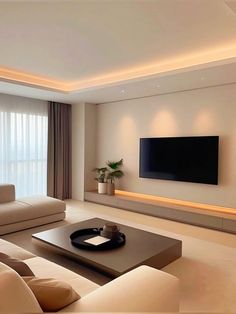 a living room with couches and a large flat screen tv mounted on the wall