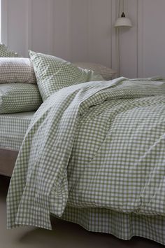 a bed with green and white checkered sheets