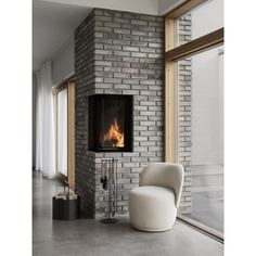 a white chair sitting in front of a brick wall with a fire place on it