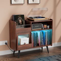 a record player is sitting on top of a book shelf with vinyl records in front of it