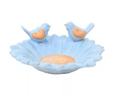 two blue birds sitting on top of a flower shaped bowl