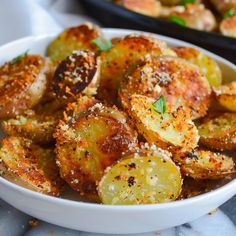 a white bowl filled with fried potatoes covered in seasoning