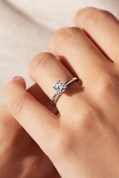 a woman's hand with a diamond ring on it