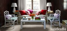 a living room filled with white furniture and red pillows