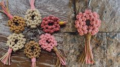 four crocheted key chains with tassels attached to them on a rock