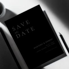 a black and white photo of a wedding save the date book next to a coffee cup