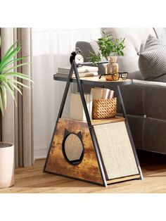 a shelf with books and other items on it in front of a couch, potted plant