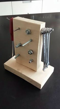 a wooden block with screws attached to it and two wrenches in the middle