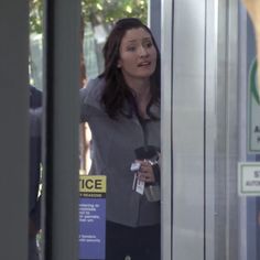 a woman is standing in an elevator and talking on the phone