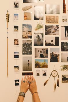 a person's hands are reaching up against a wall with many pictures on it