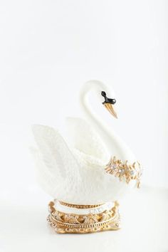 a swan figurine sitting on top of a white surface