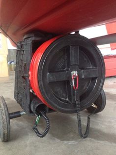 a red and black hose connected to the back end of a boat's hull