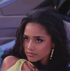 a woman sitting in the back seat of a car with her hand on her hip