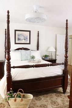 a large bed sitting in a bedroom next to a basket with flowers on top of it