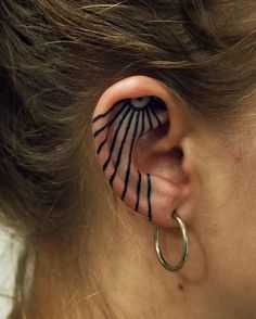 a woman's ear with tattoos on it