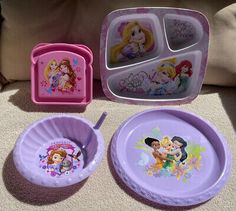 three children's plastic dishes with disney princess pictures on them, one is pink and the other is purple