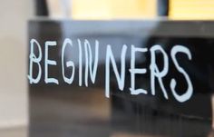 the words beginners written in white chalk on a glass door with a black frame