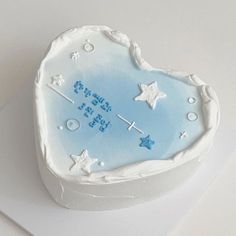 a blue heart shaped cake with stars on it